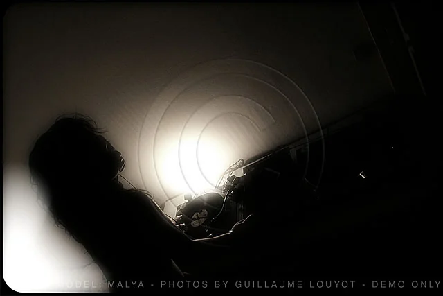 Silhouette de Malya en contre-jour devant une lumière circulaire