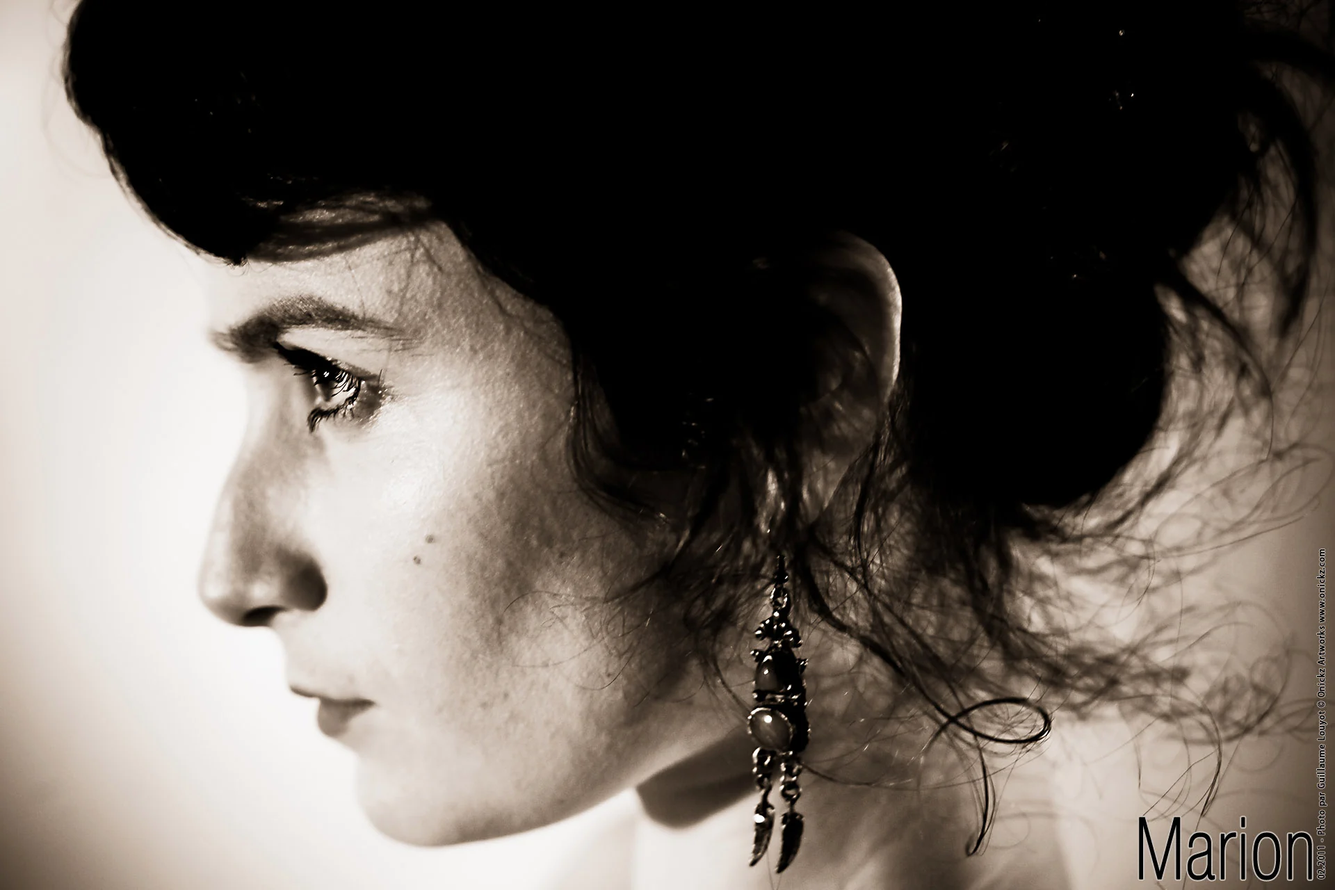 Marion de profil, les cheveux relevés et une boucle d’oreille pendante